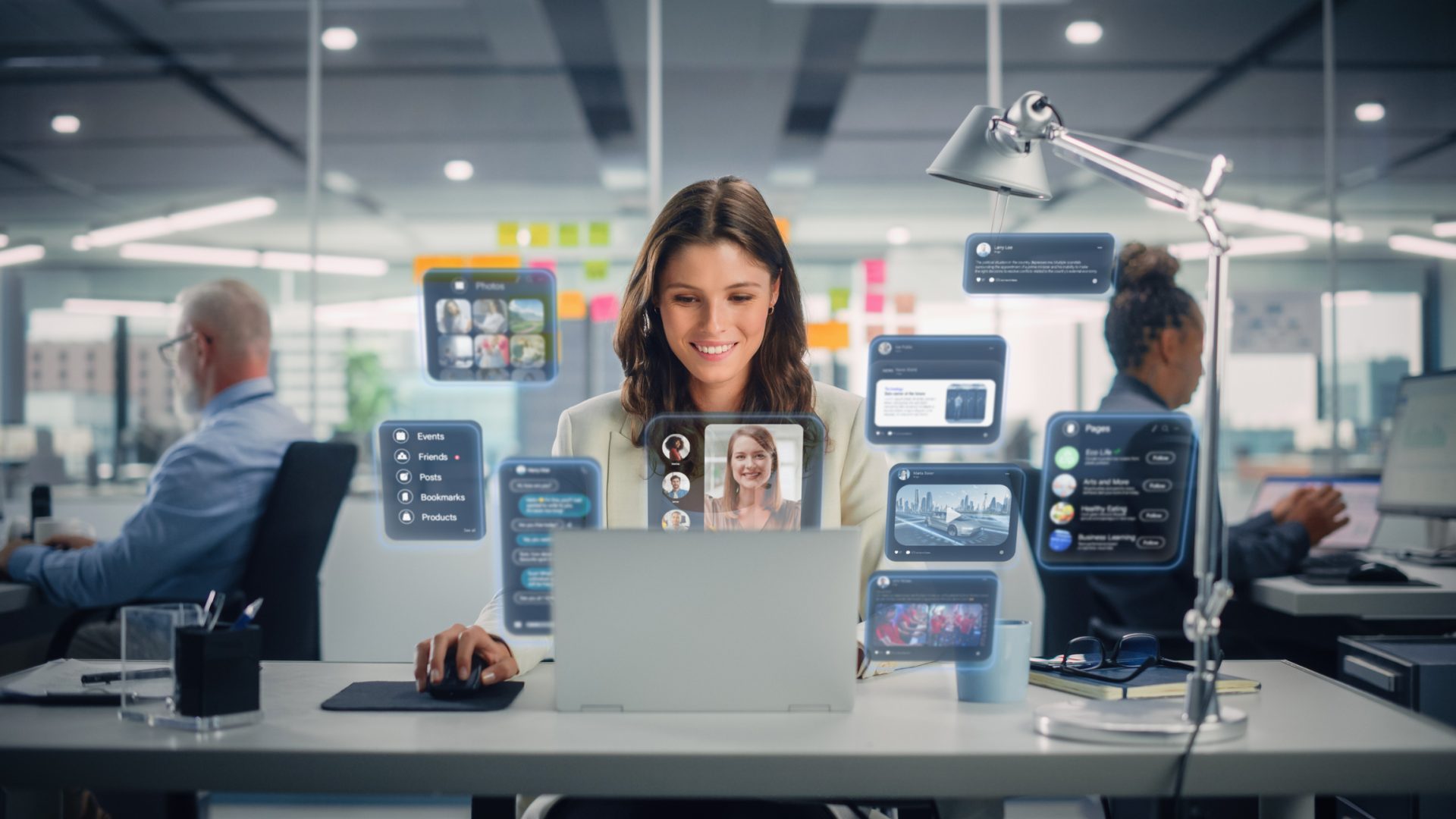 Young Businesswoman Using Laptop Computer in Office with Colleagues. Stylish Social Media Manager Smiling, Working Online Marketing Projects. VFX Hologram Edit Visualizing Social Network With Friends.